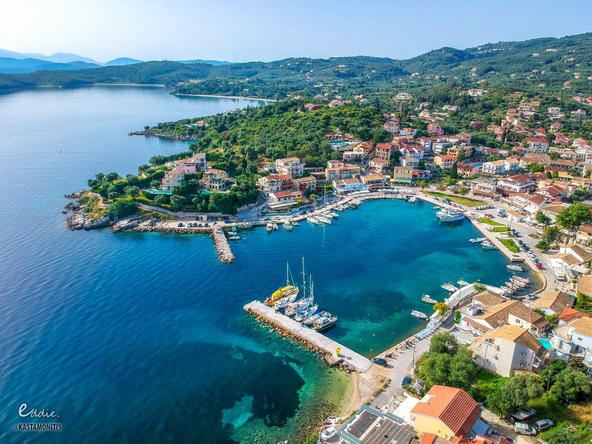 Boat moored in the turquoise water of Kassiopi harbour, Corfu