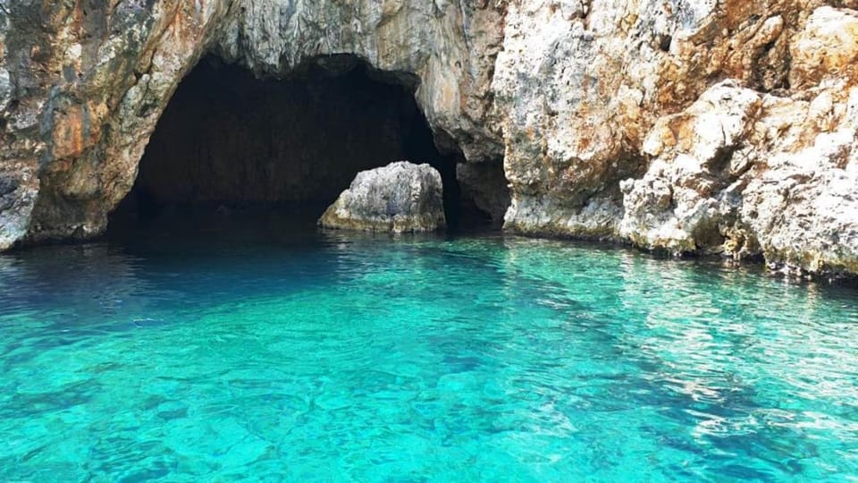 Corfu Port Shore Trip: Boat Caves or Beach Time Is the Main Trade-Off 2 Low sea cave arch above clear water near Paleokastritsa